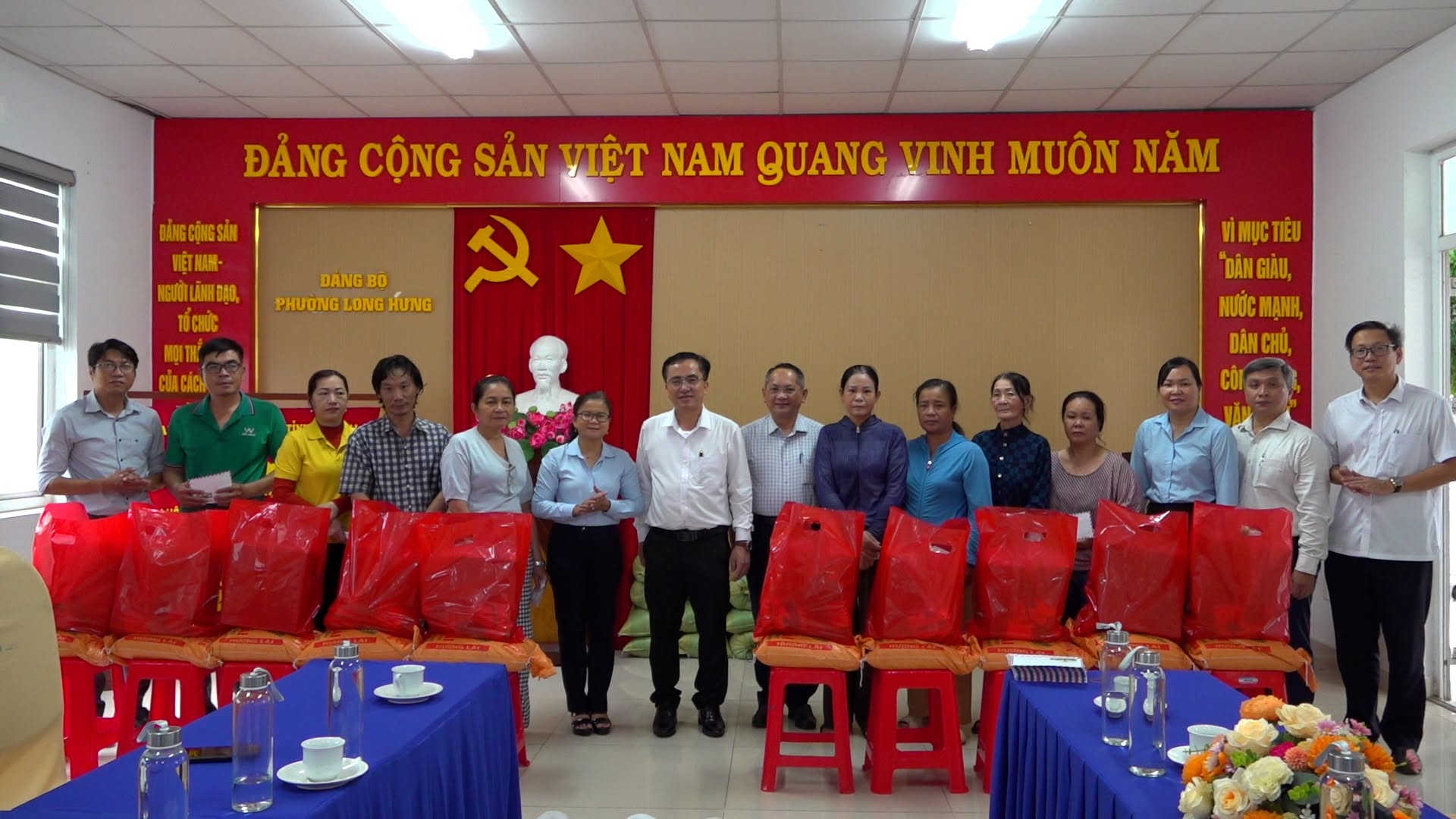 Đ/c Kiều Minh Sinh - Phó Bí thư Thường trực Đảng ủy phường Long Hưng (áo trắng đứng giữa) cùng các đại biểu tặng quà cho các hộ khó khăn
